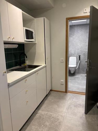 a kitchen with a sink and a microwave at Hotell Vänersborg in Vänersborg