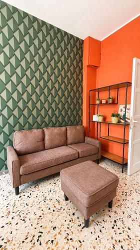 a living room with a brown couch and an orange wall at Interi Appartamenti in Centro - Holiday & Wi-Fi Ultra in Campobasso