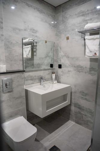 a bathroom with a white sink and a toilet at Wlat Hotel in Erbil