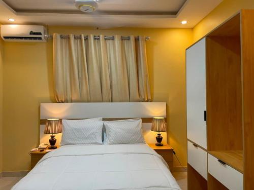 a bedroom with a large white bed with two lamps at Anaviosi Villa in Anum
