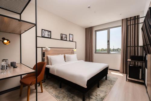 a hotel room with a bed and a desk at Ibis Tashkent Index in Tashkent