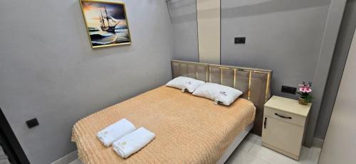 a small bedroom with a bed with two towels on it at БорБор in Osh