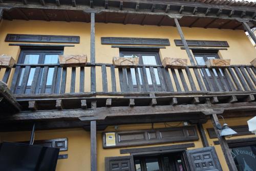 a building with a wooden balcony on the side of it at La Posada De La Magistral in Alcalá de Henares