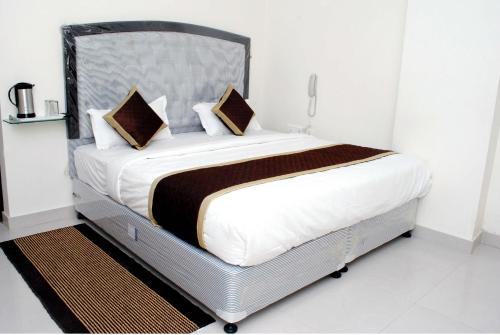a bedroom with a large bed with white sheets and pillows at Hotel Galaxy Inn in Jaipur