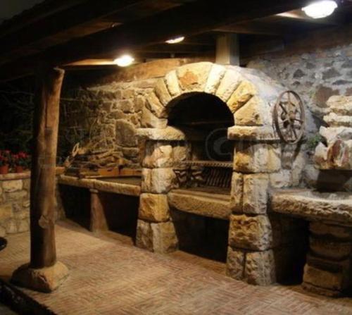 a stone oven in a room with a stone wall at Hotel IRARAGORRI in Galdakao