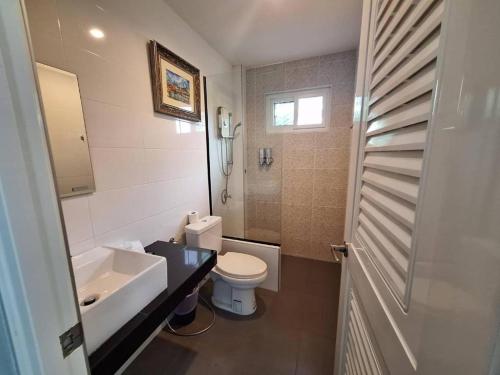a bathroom with a white toilet and a sink at Lantanoblesse in Ko Lanta