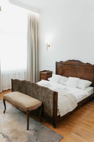 a bedroom with a large bed and a bench at Hotel Pod Zeleným Dubem in Bohumín