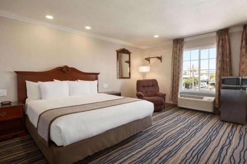 a hotel room with a bed and a chair at Days Inn by Wyndham Eureka CA in Eureka