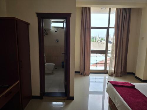 a bedroom with a door leading to a bathroom at Yiganda Hotel, Ethiopia in Bahir Dar