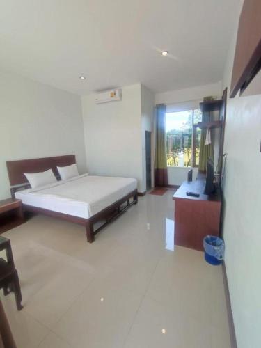 a bedroom with a bed and a television in it at Cindia Resort in Phun Phin