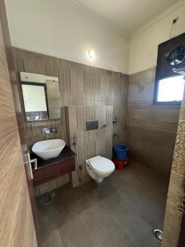 a bathroom with a toilet and a sink at Hotel Corbett Inn in Rudrapur