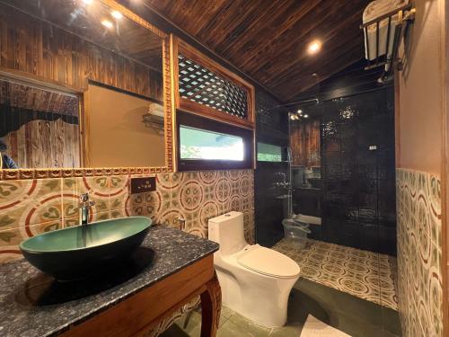 a bathroom with a sink and a toilet at The Arboreal Resort in Āmbavna
