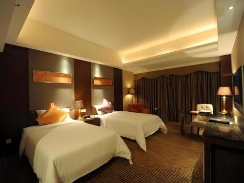 a hotel room with two beds and a desk at The Clipper Hotel in Dongguan