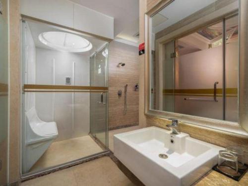 a bathroom with a sink and a shower and a mirror at The Clipper Hotel in Dongguan