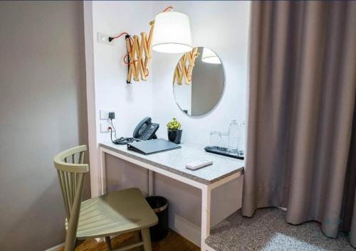 a bathroom with a vanity with a mirror and a desk at Avior Hotel in General Santos