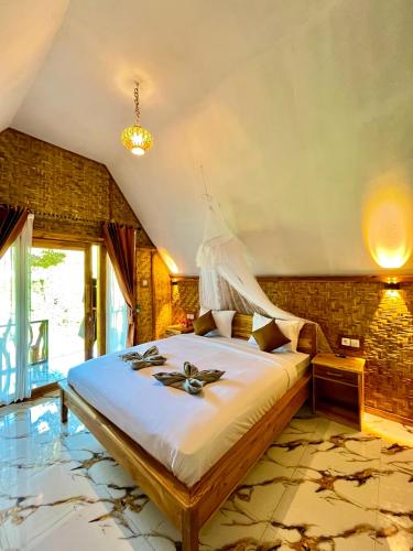 a bedroom with a large bed in a room at Azhani Bungalow in Tetebatu