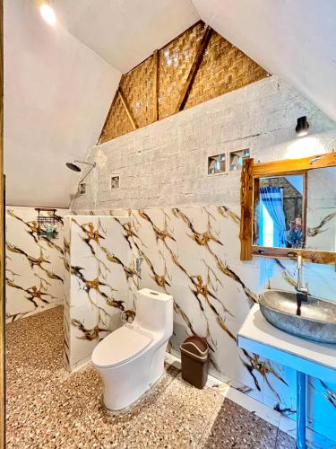 a bathroom with a toilet and a sink at Azhani Bungalow in Tetebatu
