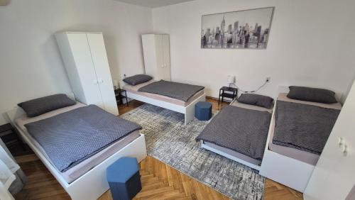 a room with three beds and a rug at InOsijek- FEELS LIKE HOME in Osijek