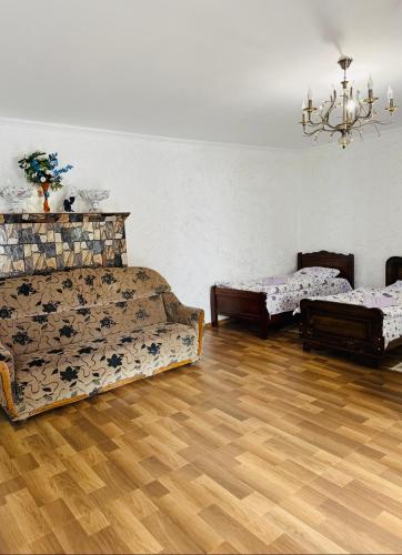a living room with two beds and a wooden floor at Family hotel ucha in Iprari