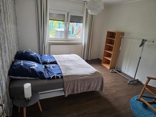 a bedroom with a bed with blue sheets and a window at Ferienwohnung Hanni in Gräfenhainichen