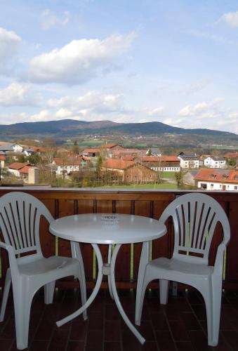 two chairs and a white table and chairs on a balcony at Hotel Lugerhof in Weiding