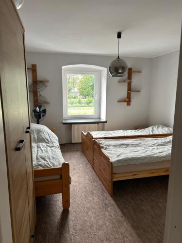 a bedroom with two beds and a window at Dolna 64 in Strzegom