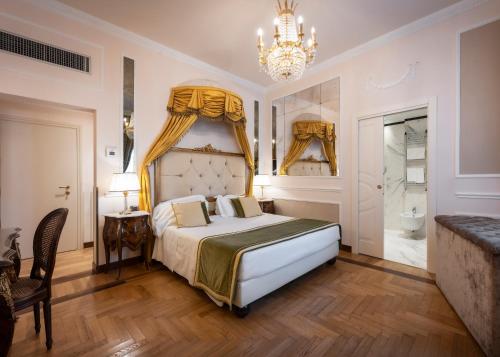 a bedroom with a king sized bed and a chandelier at Hotel Bernini Palace in Florence