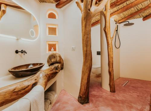 a bathroom with a wooden log sink and a toilet at Corte Bianca - Adults Only & SPA - Bovis Hotels in Cardedu