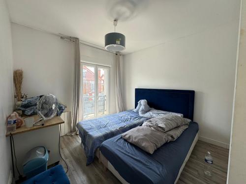 a bedroom with a blue bed and a window at Emmanuel INN 4 in Drancy