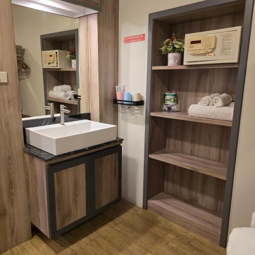 a bathroom with a sink and a mirror at Victory Place in Bangkok