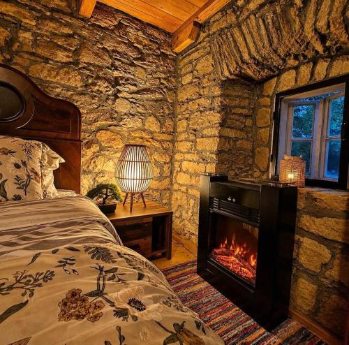 a bedroom with a fireplace in a stone wall at Old mill in Štore