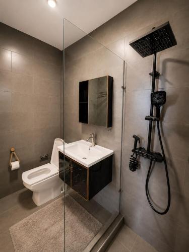 a bathroom with a toilet and a sink and a shower at La Terrace Brocus in Bouchon
