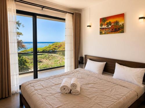 a bedroom with a bed and a large window at La Terrace Brocus in Bouchon