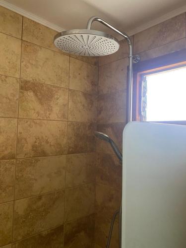 a bathroom with a shower with a glass door at theVotsalo Eco house in Agios Padeleimon