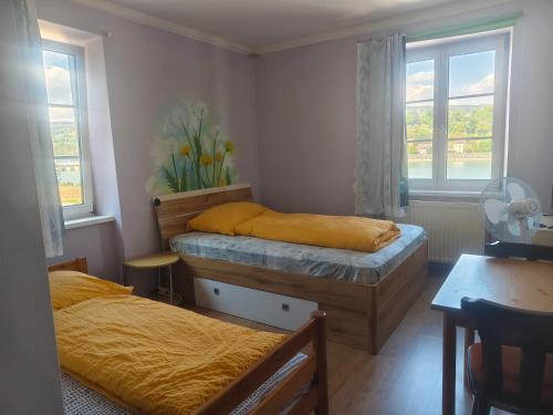 a bedroom with two beds and a table and windows at Asia wok gasthof in Ybbs an der Donau