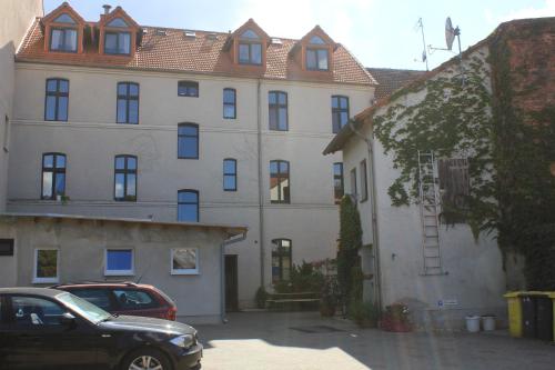 a large building with a car parked in front of it at Tommel Apartments - Boardinghouse in Haldensleben