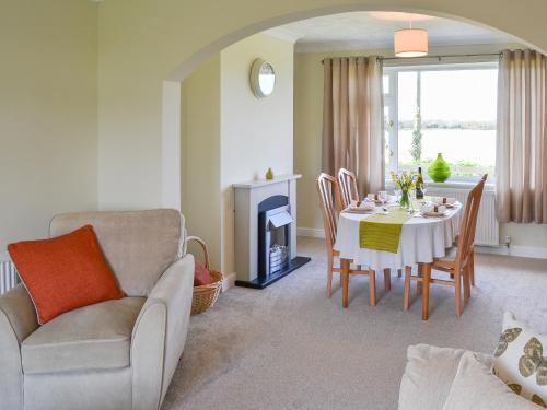 a living room with a table and a chair at California Halt in Scratby