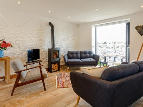 a living room with two couches and a fireplace at Wrens Perch in Brixham