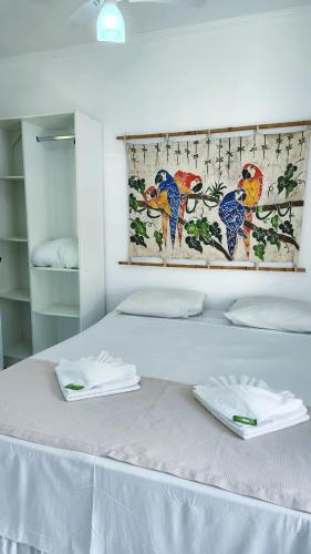 a white bed with two white towels on top of it at Pousada Lacosta in Ilhabela