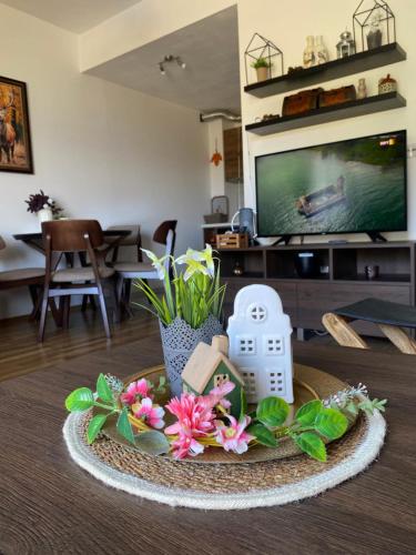 a living room with a table with flowers and a tv at Moun2 in Mavrovo