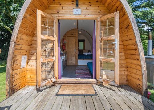 an open door of a wooden hobbit house at Apple Mount Retreat in Preston