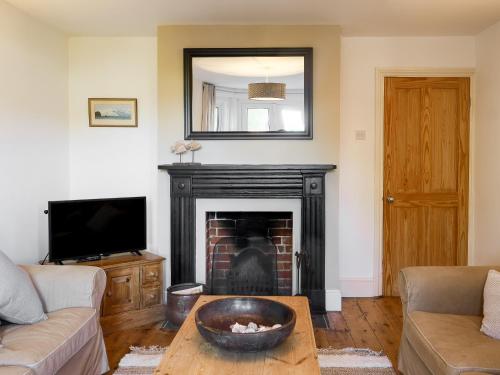 a living room with a fireplace and a mirror at Loreto in Freshwater