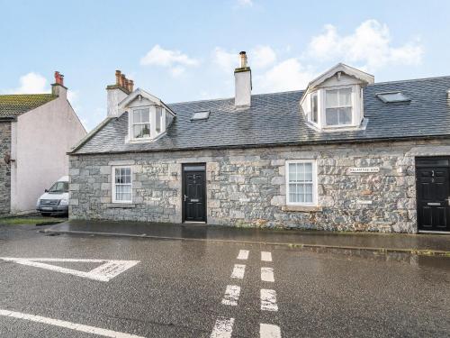 a stone house with a car parked in front of it at Killantrae Burn in Port William