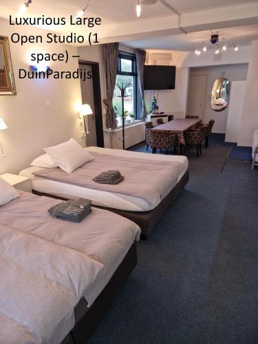 a hotel room with two beds and a dining room at DuinVliet - Zandvoort Dunes & Free Parking in Bentveld