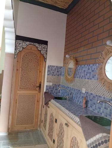 a kitchen with a sink and a door in a room at Dar Bani in Zagora