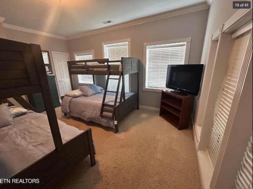 a bedroom with a bunk bed and a flat screen tv at Cove Manor in Maynardville