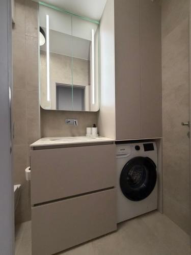 a bathroom with a washing machine and a sink at MOOD Apartment Piešťany Centrum, parking, terasa in Piešťany