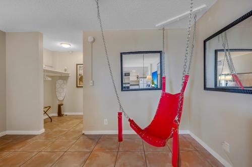 a red swing hanging from a wall in a living room at RoofTop Resort - Hollywood Beach, Florida in Hollywood