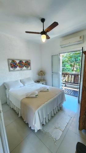a bedroom with a bed and a ceiling fan at Pousada Lacosta in Ilhabela