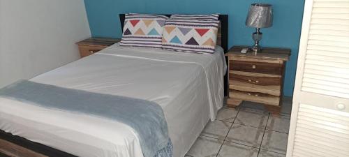 a bedroom with a bed and a night stand with a lamp at Villa Vista in Steer Town